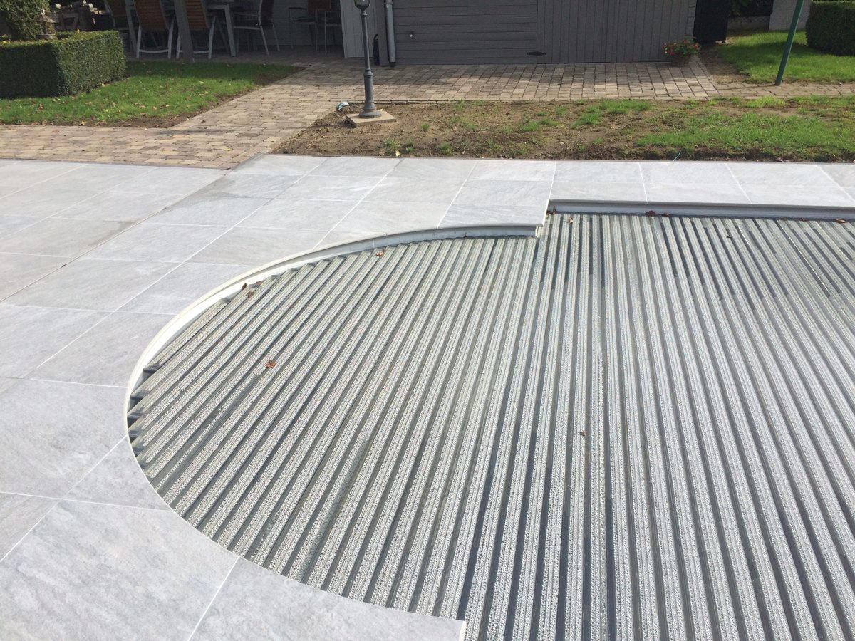 Terras afgewerkt met terrastegels in natuursteen rond een zwembad