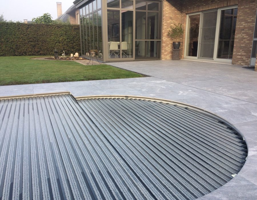 Terras in natuursteen en terrastegels aangelegd rond een zwembad
